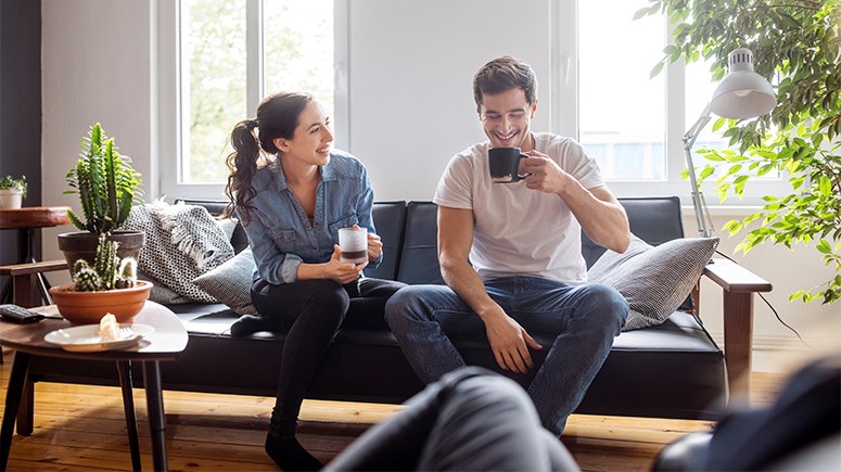 Male and Female Couple drinking coffee in sitting room